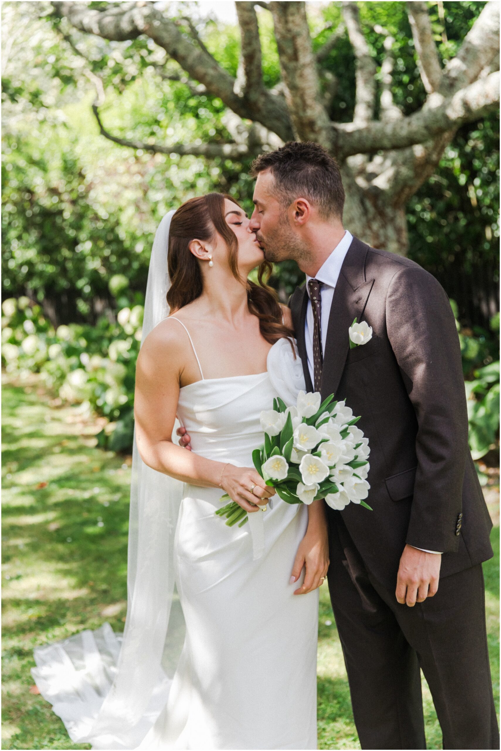 Marika and Tom kissing during their Cambridge garden wedding
